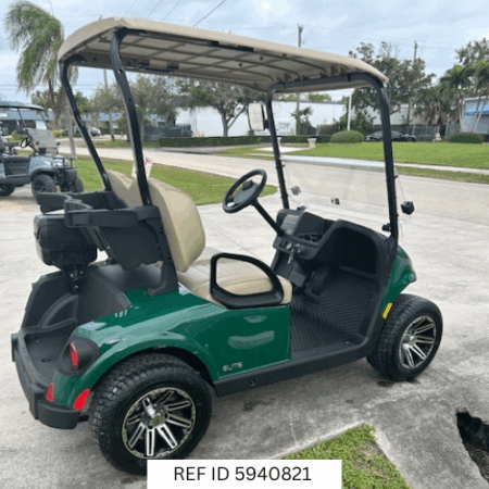 2026 E-Z-GO RXV Freedom Elite golf cart in green with 12-inch wheels, premium seats, Sunbrella enclosure, fan, windshield, mirrors, USB port, LED lights, and Samsung Lithium battery