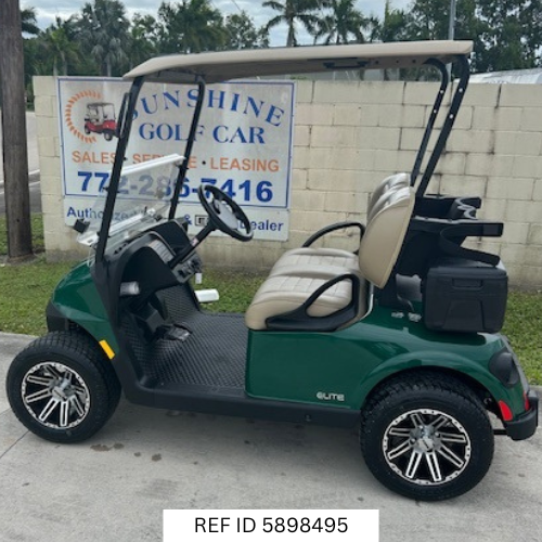 2025 E-Z-GO RXV Freedom Elite golf cart in green with 12-inch wheels, premium seats, Sunbrella enclosure, fan, windshield, mirrors, USB port, LED lights, and Samsung Lithium battery